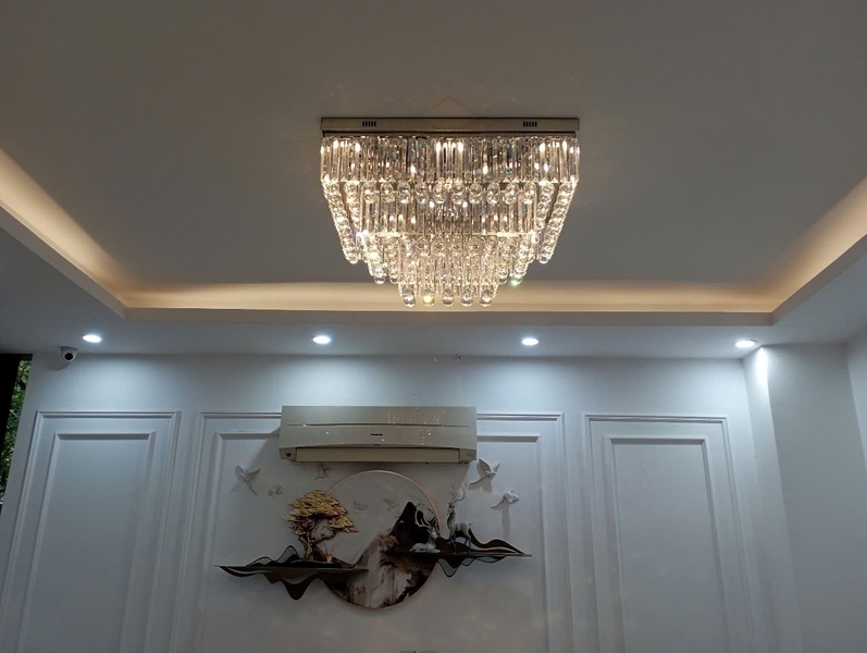 Đèn chùm pha lê thả thông minh PL024 gồm 3 tầng thanh tam giác trắng, hạt D40 đèn led COB dimer 3 màu có điều khiển xa, mâm inox gương trắng hình chữ nhật, KT(mm): 1500 x 600 x 450