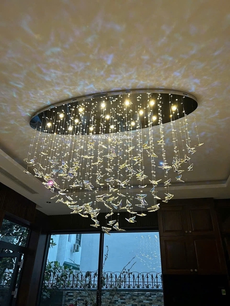 Đèn chùm pha lê thả thông minh 064PL1 gồm 80 con bướm pha lê dây có bấm hạt pha lê bát giác , 10 mắt COB dimmer L40 có điều khiển xa, mâm elip inox gương vàng.KT(mm): L1000 x W300 x H1000